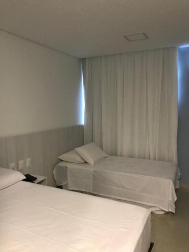 塔曼达雷APART HOTEL MARINAS TAMANDARÉ - Flat 104的酒店客房设有两张床和窗户。