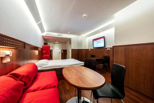 于韦斯屈莱韦斯屈莱欧美娜酒店的酒店客房设有红色的沙发和桌子。