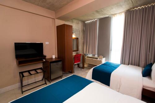 圣胡安PR梦想旅馆的酒店客房设有两张床和一台平面电视。