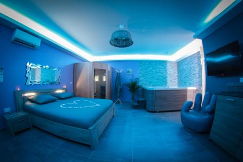 乐罗夫Nuit vip spa sauna privatif的蓝色卧室配有一张床和一个浴缸