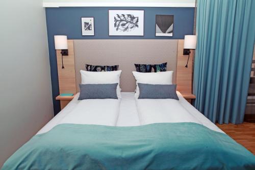 斯泰恩谢尔格兰德施泰因克杰品质酒店的一间卧室配有一张带蓝色墙壁的大床