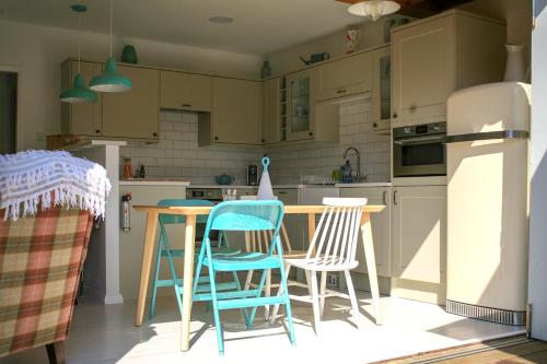 坎伯利Owlers Retreat的厨房配有桌椅和冰箱