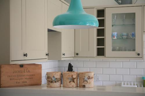 坎伯利Owlers Retreat的厨房配有白色橱柜和蓝色灯具
