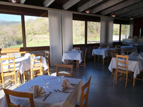 Laino BorgoPalia's Hotel的餐厅设有白色的桌椅和窗户。