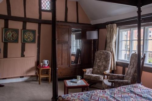 贝里圣埃德蒙兹St Mary’s Bed & Breakfast的一间卧室配有一张床、一把椅子和窗户。