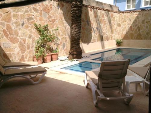 安塔利亚赫尔德酒店的一个带两把椅子的庭院和一个游泳池