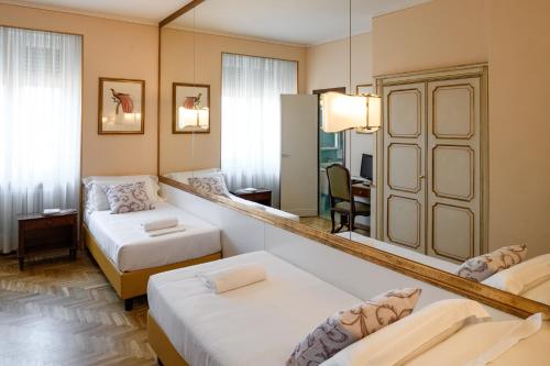 特雷维索欧陆酒店的酒店客房,设有两张床和镜子