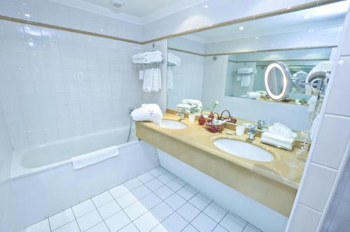 沙托贝尔纳尔Hôtel L'Yeuse - Les Collectionneurs的浴室设有2个水槽、镜子和浴缸。
