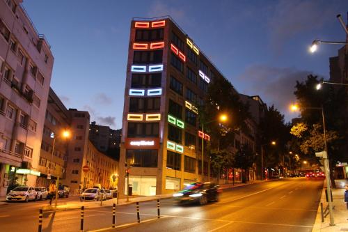 里斯本easyHotel Lisbon的夜幕降临的城市街道上一座高楼