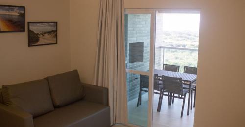 萨利诺波利斯SALINAS PARK RESORT的带沙发和桌子的客厅以及阳台。