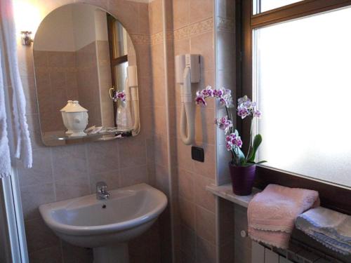 Narzole卡希纳迪因别墅 的浴室设有水槽、镜子和鲜花
