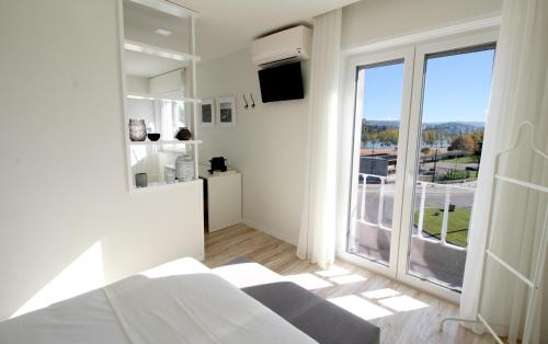 科英布拉JR Studios & Suites I Rius I的白色的客房设有床和大窗户