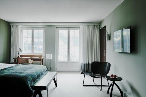 阿德尔博登寒武纪酒店的一间卧室配有一张床、一把椅子和一张书桌