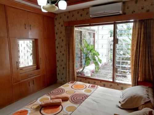 茂物GIO Guesthouse Bogor的一间卧室设有一张床和一个大窗户