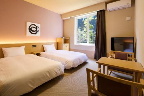 天理市GRANDVRIO HOTEL NARA -WAKURA- -ROUTE INN HOTELS-的酒店客房设有两张床和电视。
