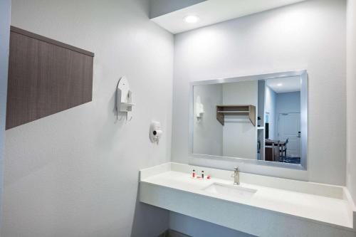 休斯顿Baymont by Wyndham Houston Hobby Airport的一间带水槽和镜子的浴室