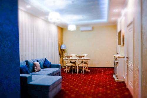 秋明拉迅尼贝拉格酒店的客厅配有蓝色的沙发和桌子