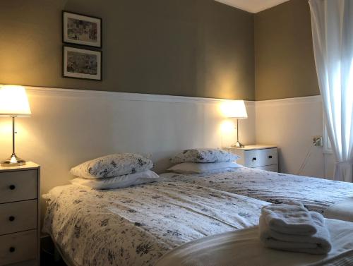 奥斯布鲁佩奥洛夫加登酒店的一间卧室配有一张带两盏灯和毛巾的床。