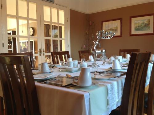 都柏林Annandale House的一间用餐室,配有一张带白色桌布的桌子