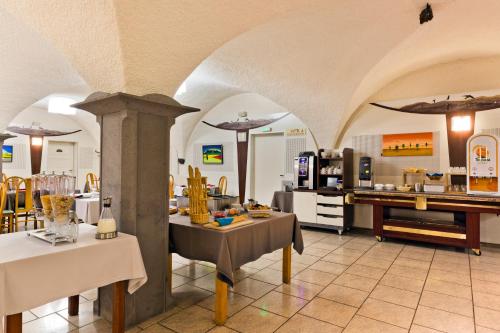 奥尔西讷飞燕酒店的一间带拱门和桌子的餐厅和一间厨房