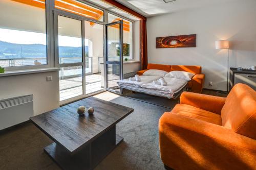伏尔塔瓦河畔利普诺Hotel STAR Lipno的客厅配有橙色沙发和桌子
