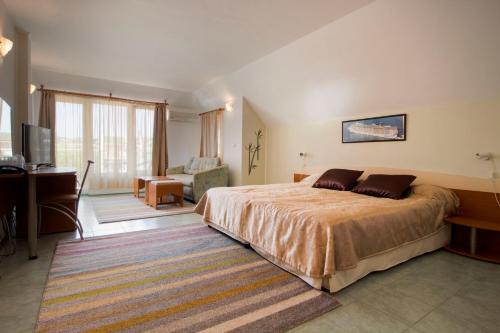 圣弗拉斯家庭金星大酒店的一间卧室配有一张大床、一张桌子和一张书桌