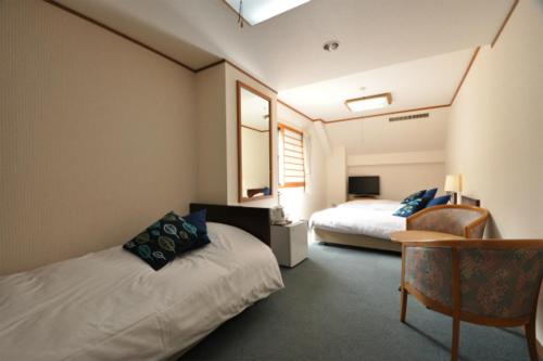 白马村白马山野酒店的酒店客房,配有两张床和椅子