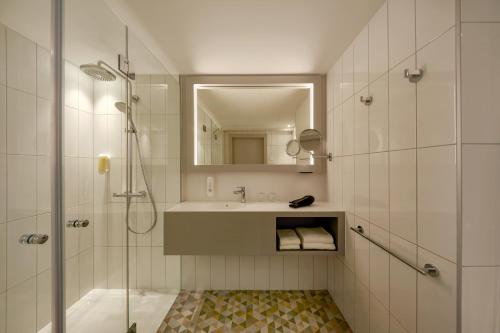 维也纳维也纳H酒店的带淋浴、盥洗盆和镜子的浴室