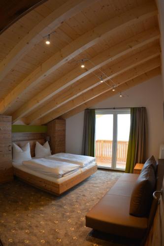 施特格Pension Alpenblick的一间卧室设有一张大床和一个大窗户