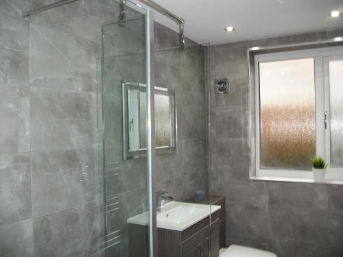 东基尔布赖德Westpark Apartment的带淋浴、盥洗盆和镜子的浴室
