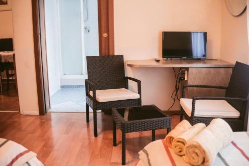 佩罗圣莫尼卡住宿加早餐旅馆的客厅配有两把椅子和电视