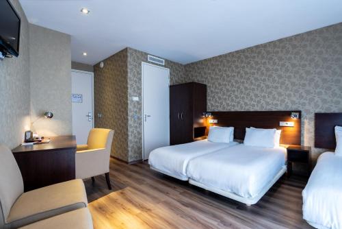 阿姆斯特丹咖啡酒店的酒店客房带两张床、一张桌子和椅子。