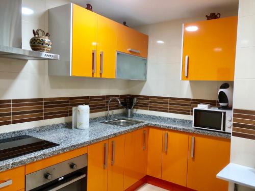 安特克拉CENTRO ANTEQUERA Moderno Apartamento de Santa Cruz的厨房配有橙色橱柜和水槽