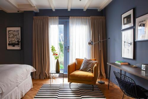 阿姆斯特丹suite no 7的卧室配有床、椅子和窗户。