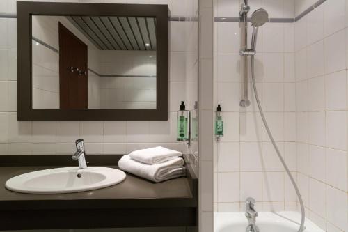 隆勒索涅Hôtel du Béryl, Lons-le-Saunier的浴室配有盥洗盆和带镜子的淋浴