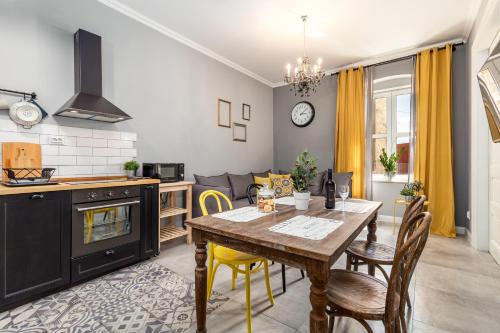 里耶卡Karolina apartments的厨房以及带木桌和椅子的用餐室。