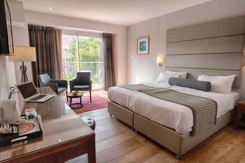 提比里亚阿斯托利亚加利利酒店 的配有一张床和一张书桌的酒店客房