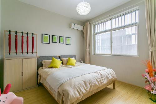 西安西安市莲湖区·回民街·路客精品公寓·00154940的一间卧室配有一张带黄色枕头的床和一扇窗户