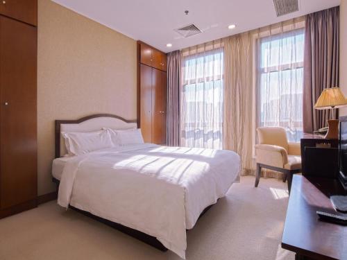 大连大连雅泰服务公寓（原盛捷港湾服务公寓）的卧室配有一张白色大床和电视。