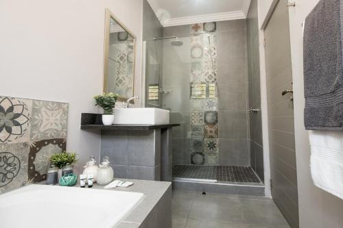 德班Hillside Guesthouse Umhlanga的一间带水槽和淋浴的浴室