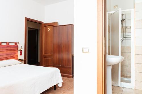 托雷斯港La Mezzanella Guesthouse的一间卧室配有一张床,浴室设有水槽