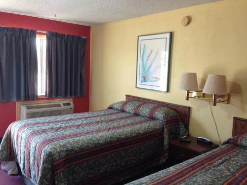 De Leon德莱昂汽车旅馆的酒店客房设有两张床和窗户。