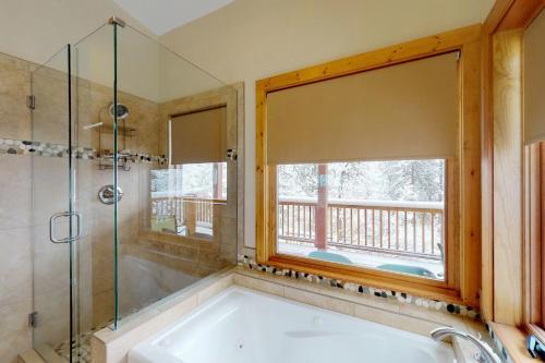 Green Mountain FallsChipmunk Cabin的带浴缸的浴室和窗户。