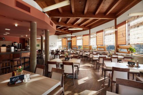 日茄基Wellness Hotel Říčky的餐厅设有木制天花板和桌椅