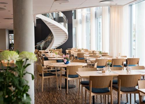 兰斯克鲁纳Hotel Öresund Conference & Spa的一间带桌椅的餐厅以及螺旋楼梯