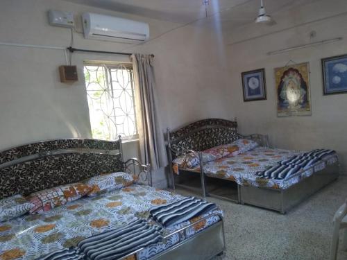 马尔冈Stay Goa的一间卧室设有两张床和窗户。