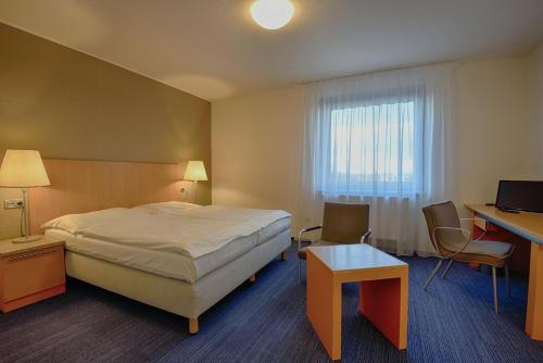 布拉格亨丽埃塔酒店的配有一张床、一张书桌和一扇窗户的酒店客房