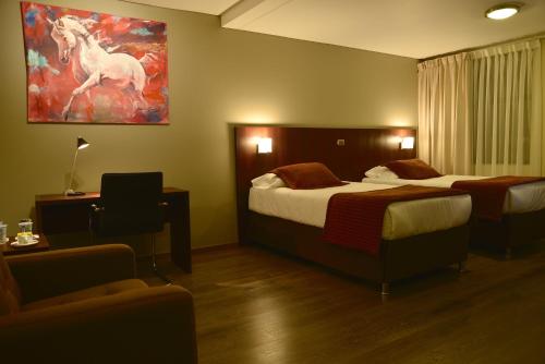 圣费尔南多Hotel Manso de Velasco的酒店客房设有两张床,并画有一幅马
