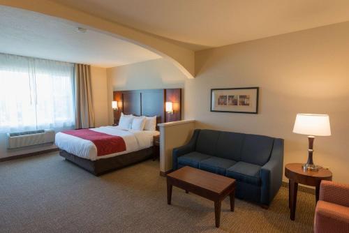 斯普林菲尔德Comfort Suites Springfield RiverBend Medical的配有一张床和一把椅子的酒店客房
