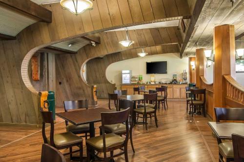 北本德库斯湾品质酒店的餐厅拥有木墙和桌椅